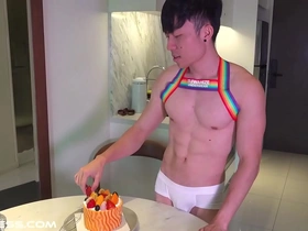 This fit Asian man with a nice six pack is enjoying a cake and teasing at the same time.