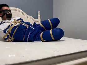 Young Asian man in hogtie bondage with blindfold and gag